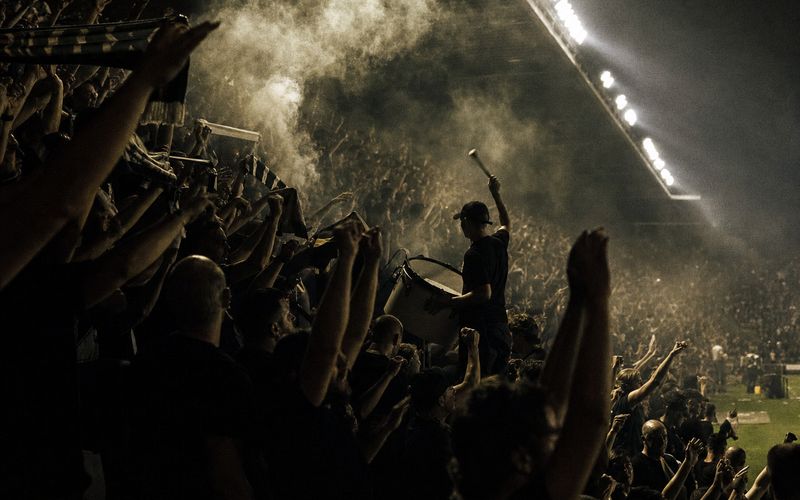 Football supporters singing on a floodlit terrace on matchday in Montreal